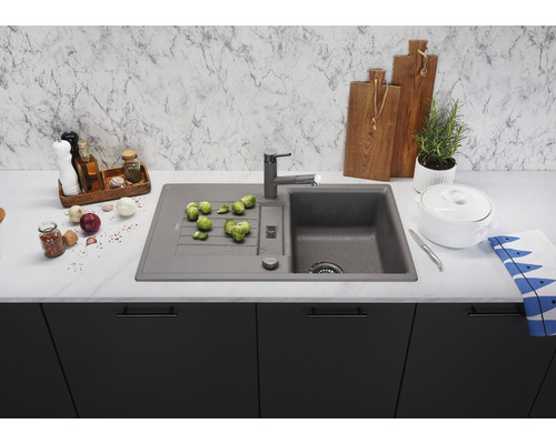 Évier de cuisine avec égouttoir, robinetterie et légumes sur un plan de travail