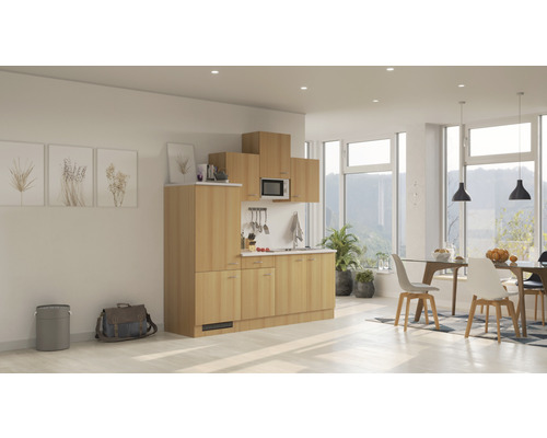 Cuisine complète avec armoires, évier, micro-ondes et hotte aspirante dans une pièce lumineuse et moderne.