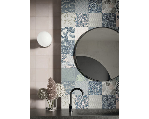 Badezimmer mit floral gemusterten Wandfliesen, Spiegel, Armatur und Blumen in Vase