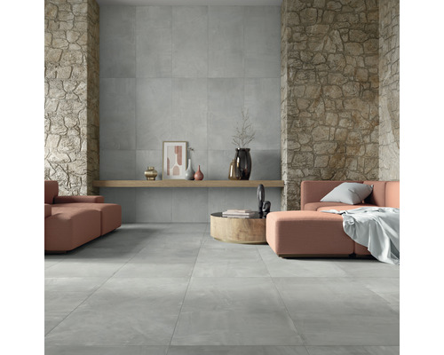Salon avec carrelage de sol gris et carrelage mural aspect pierre.