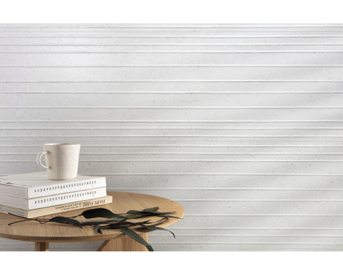 Helle Wandfliese mit horizontalem Rillenmuster als Hintergrund für einen Tisch mit Büchern und einer Tasse