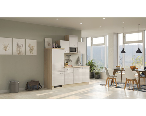 Cuisine compacte dans une pièce lumineuse et moderne avec coin repas et grandes fenêtres.