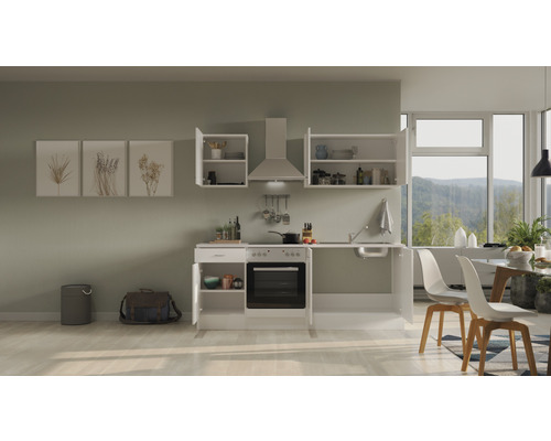 Cuisine complète avec placards hauts, hotte aspirante, évier et cuisinière électrique dans une pièce lumineuse