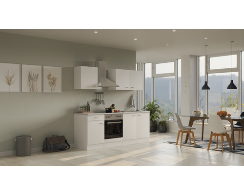 Cuisine lumineuse avec placards intégrés, hotte aspirante et table à manger dans un espace de vie moderne.