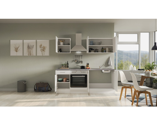 Cuisine compacte avec éléments hauts et bas, évier, cuisinière et hotte aspirante dans une pièce lumineuse