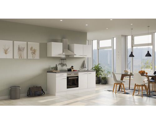 Cuisine claire et conviviale avec armoires blanches, hotte aspirante et coin repas