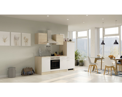 Helle Küche mit Essbereich, inklusive Küchenschränken, Spüle, Herd und Dunstabzugshaube.