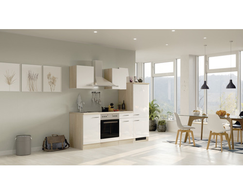 Cuisine intégrée claire avec appareils électriques et coin repas dans une pièce aménagée moderne.