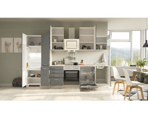 Cuisine lumineuse avec armoires encastrées, réfrigérateur-congélateur, cuisinière et lave-vaisselle.