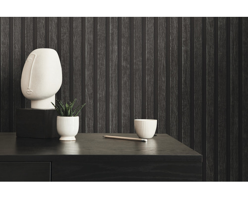 Nature morte décorative sur un bureau en bois foncé devant un papier peint mural texturé.