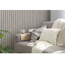 Salon avec lambris aspect bois, canapé avec coussins et couverture