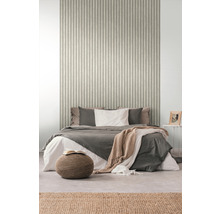 Chambre avec lit devant un mur avec du papier peint à rayures