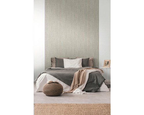 Chambre avec lit devant un mur avec du papier peint à rayures