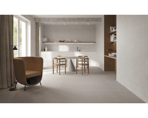 Espace de vie lumineux avec carrelage, table à manger, chaises et fauteuils.