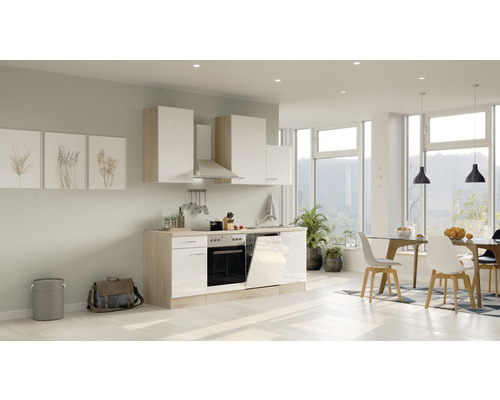 Cuisine claire avec des armoires hautes et basses, une hotte aspirante et des appareils encastrés dans une pièce aménagée de manière moderne.