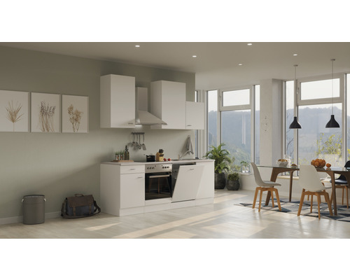 Cuisine moderne avec armoires blanches, hotte aspirante et coin repas dans une pièce lumineuse.