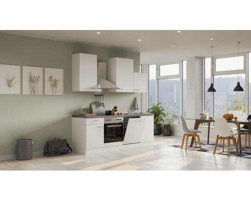 Cuisine claire avec armoires blanches, hotte aspirante et coin repas