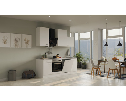 Helle Einbauküche mit weißen Schränken, Dunstabzugshaube und Essbereich mit Tisch und Stühlen.