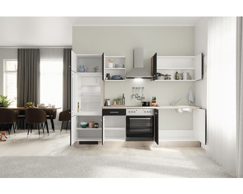 Cuisine intégrée avec réfrigérateur, cuisinière, évier et placards dans une pièce lumineuse