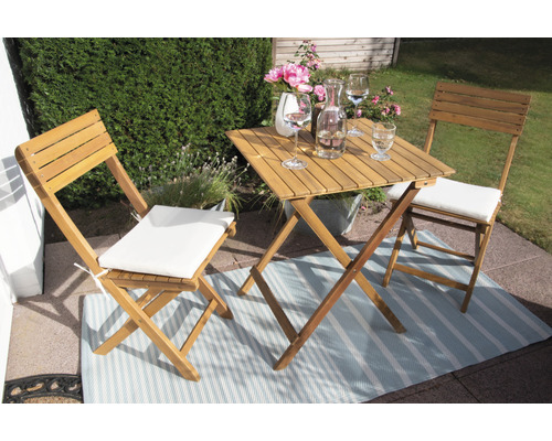 Table de jardin en bois avec deux chaises et coussins d''assise sur un balcon