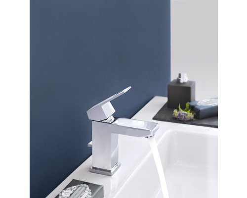 Glänzende Waschtischarmatur im Badezimmer mit fließendem Wasser