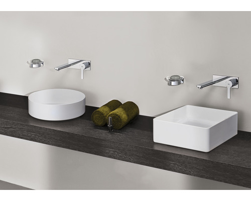 Salle de bains avec vasques à poser rondes et rectangulaires, robinets et serviettes sur une étagère foncée