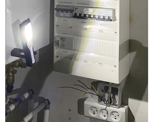 Installationsszene mit Verteilerkasten, Steckdosen und Taschenlampe