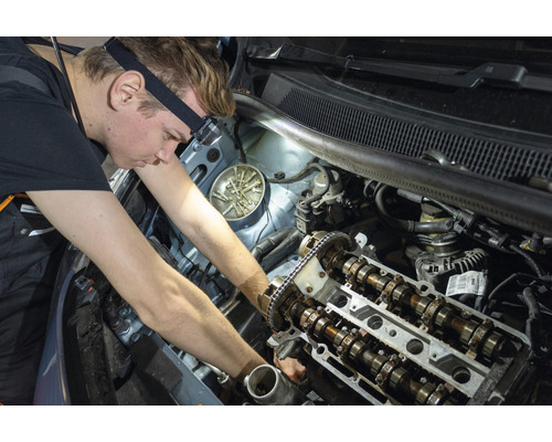 Un mécanicien répare le moteur d''une voiture.