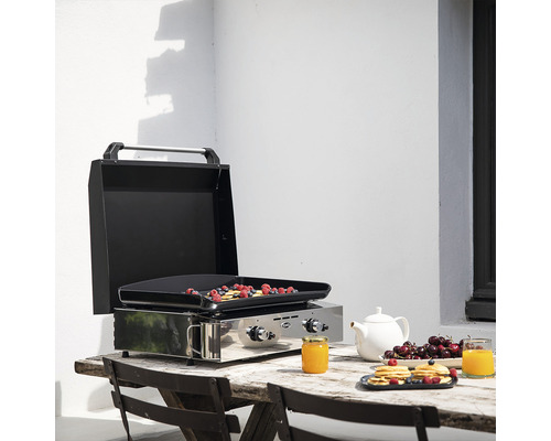 Grill de table avec couvercle ouvert et aliments préparés sur une table en bois à l''extérieur