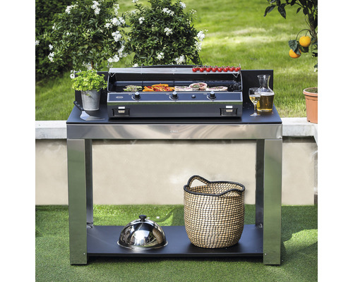 Cuisine extérieure avec barbecue, table d''appoint et grillades dans le jardin.