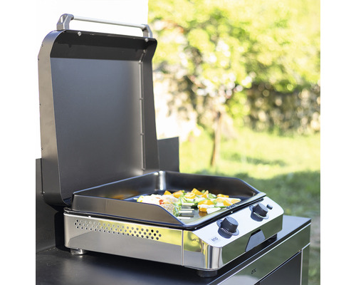 Barbecue à gaz ouvert avec des légumes sur la plaque de cuisson