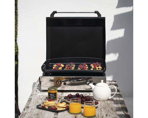 Gril à gaz avec crêpes préparées, baies et boissons sur une table