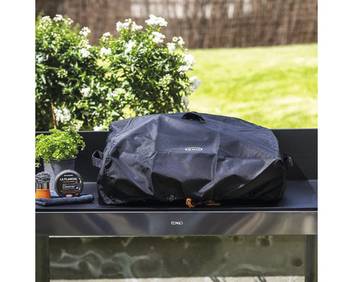 Housse de barbecue sur une cuisine extérieure avec kit de nettoyage