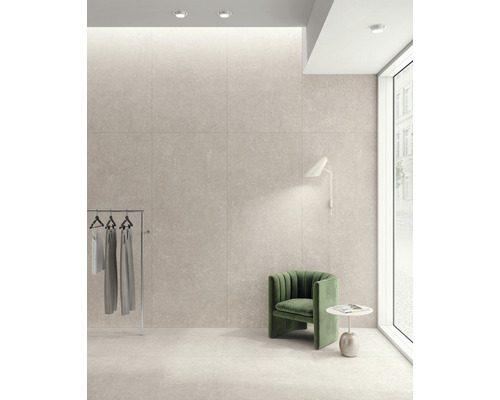 Pièce lumineuse avec carrelage mural et au sol, portant à vêtements et fauteuil