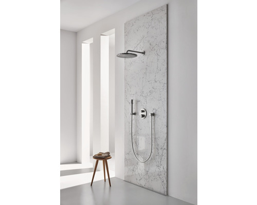 Duschset mit Kopfbrause, Handbrause und Armatur an einer Marmorwand in einem hellen Badezimmer.