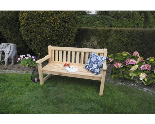 Banc de jardin en bois avec coussin, livre et fraises dans le jardin
