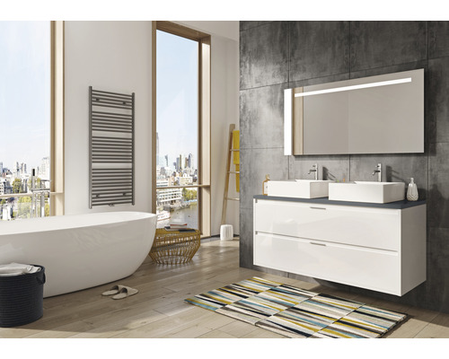 Salle de bain lumineuse avec baignoire, meuble-lavabo avec deux lavabos, miroir éclairé et sèche-serviettes