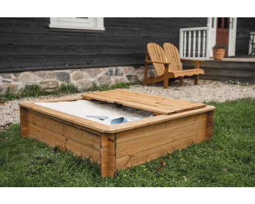 Bac à sable en bois avec couvercle et jouets de sable dans le jardin