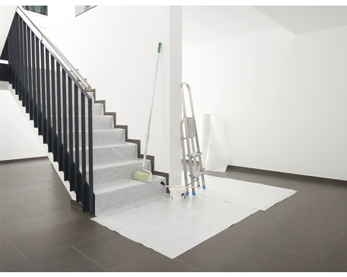 Préparatifs pour la peinture d''une cage d''escalier avec du matériel de protection, une échelle et un rouleau à peinture