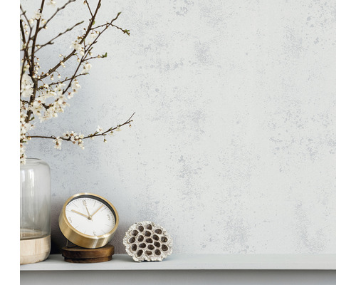 Scène décorative avec des branches fleuries dans un vase, une horloge dorée et une fleur de lotus séchée sur une étagère