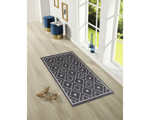 Rechteckiger Teppich mit geometrischem Muster auf einem Holzboden