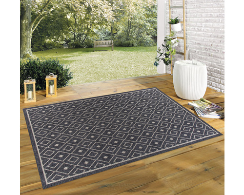 Teppich mit Rautenmuster auf einer Holzterrasse im Garten.