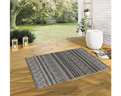 Extérieur avec un tapis rectangulaire à motifs géométriques sur des planches de bois