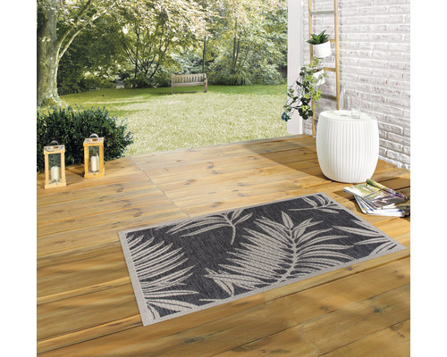 Gartenszene mit gemustertem Outdoor Teppich auf einer Holzterrasse