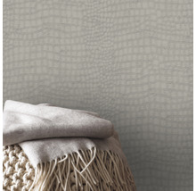 Papier peint à motif peau de crocodile et couverture à franges