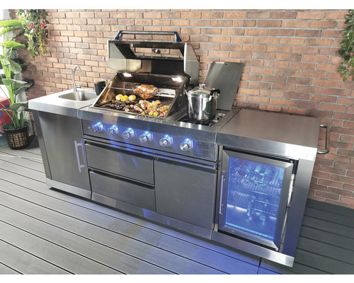 Cuisine d''extérieur en acier inoxydable avec grill, évier et réfrigérateur sur une terrasse