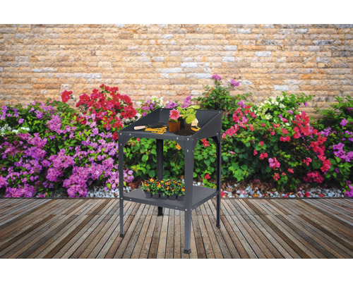 Table de jardin pour rempoter avec fleurs et outils de jardinage