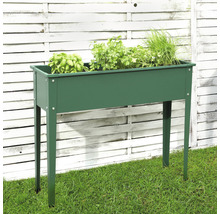 Jardinière sur pieds en métal avec herbes aromatiques sur pelouse devant une clôture en bois