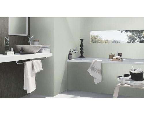 Salle de bain lumineuse avec lavabo, miroir et baignoire pour une ambiance propre et moderne.