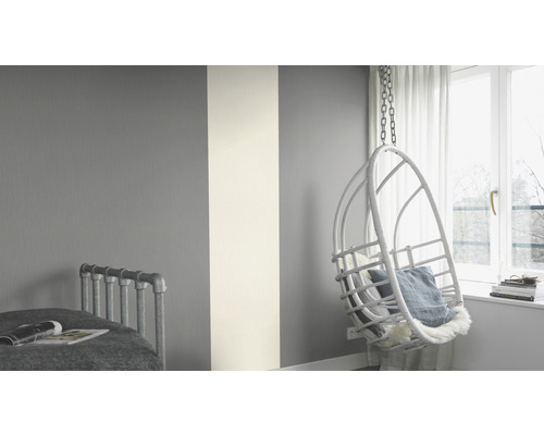 Schlafzimmer mit Wandgestaltung in Grau und Weiss und Hängekorbsessel